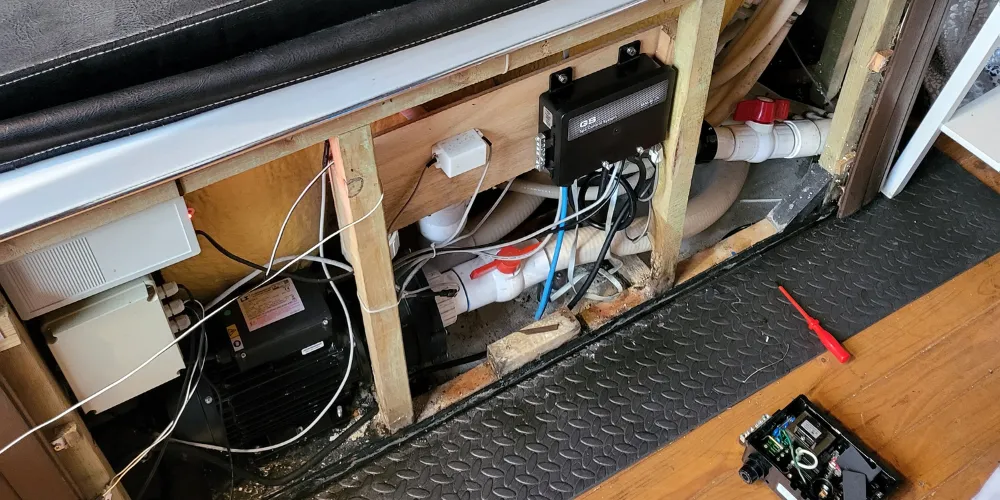 Hot tub pump, control pack and pipework behind an open service panel